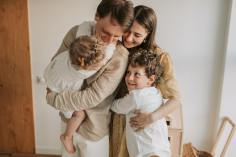 Man, woman and two children having a hug.