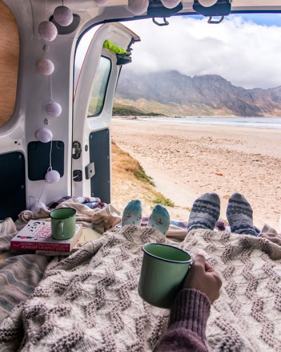 Couple enjoying a cup of tea in their camper van.