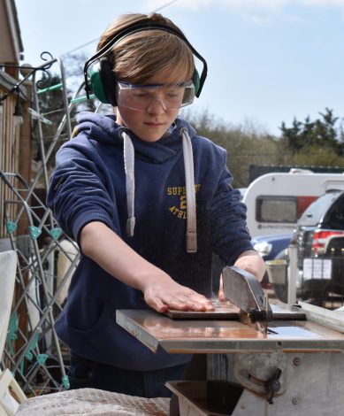 Boy cutting tiles on a diamond saw.