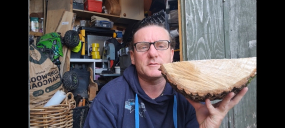 A man holding half a log.