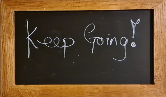 A blackboard with Keep going written on it.